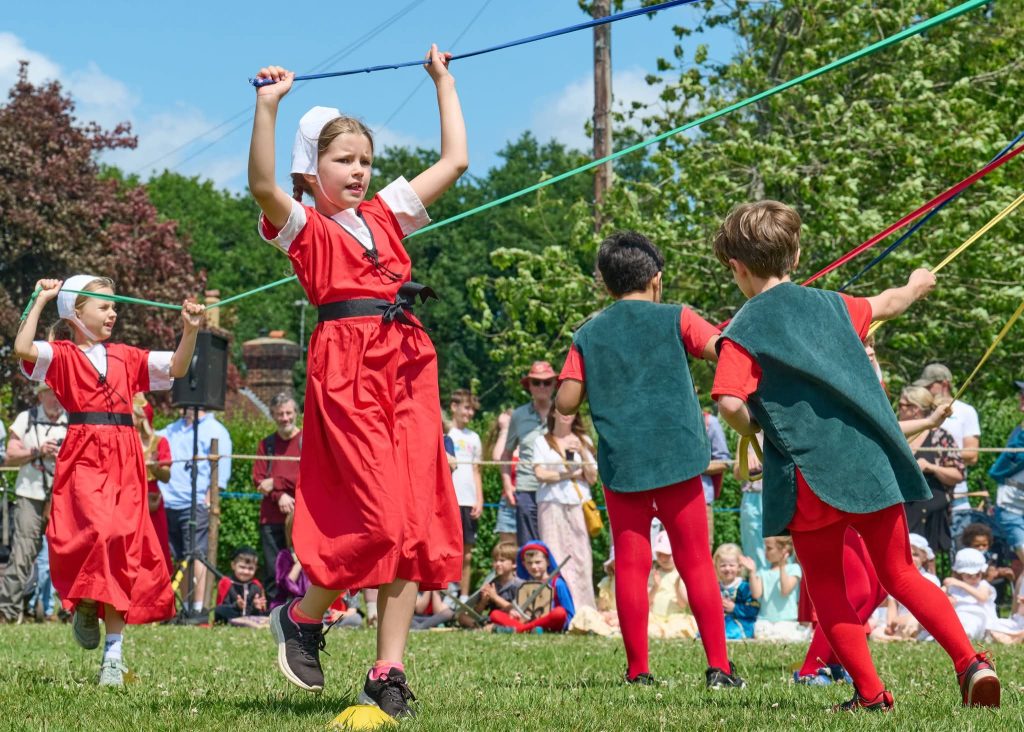 Boys and girls dancing around the maypole
